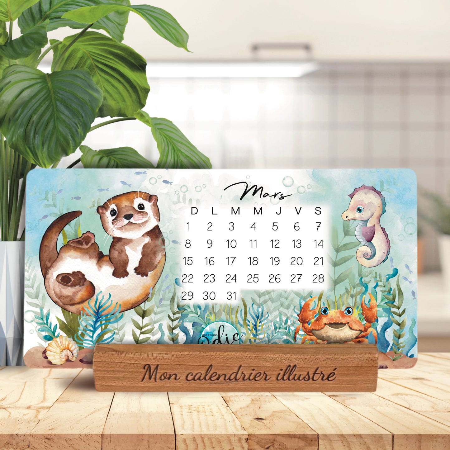 Calendrier illustré 2026 – mois de mars avec loutre, hippocampe et crabe, base en bois gravée "Mon calendrier illustré", fait main au Québec