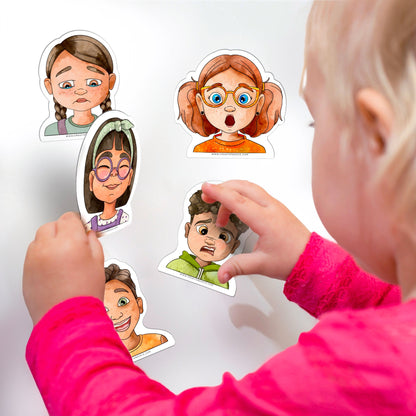 Gros plan d'un enfant manipulant les aimants d'émotions sur une surface magnétique