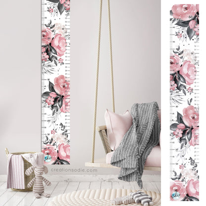 Détail de l'échelle de croissance florale rose et noire collée au mur avec les bandes déja installées. Imprimée au Québec