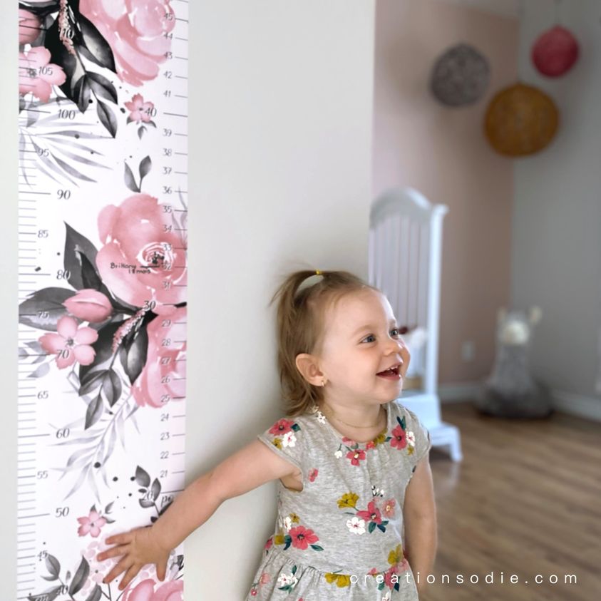 Fillette souriante à côté de l'échelle de croissance aquarelle roses, décoration murale personnalisée pour chambre d'enfant